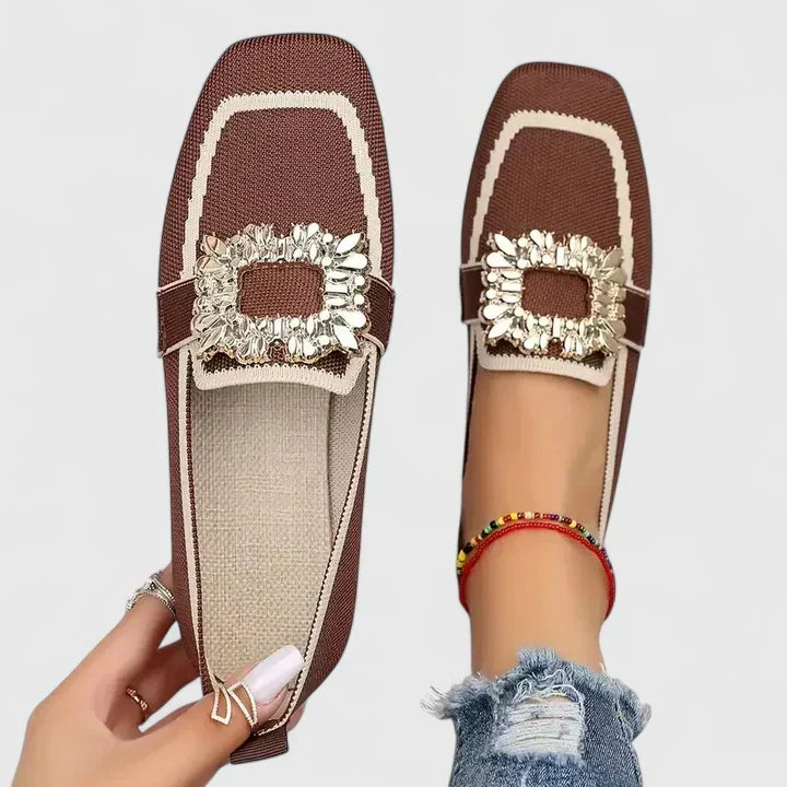 Stylish women's black flat loafers with a prominent crystal buckle and modern square toe, ideal for dress or casual.