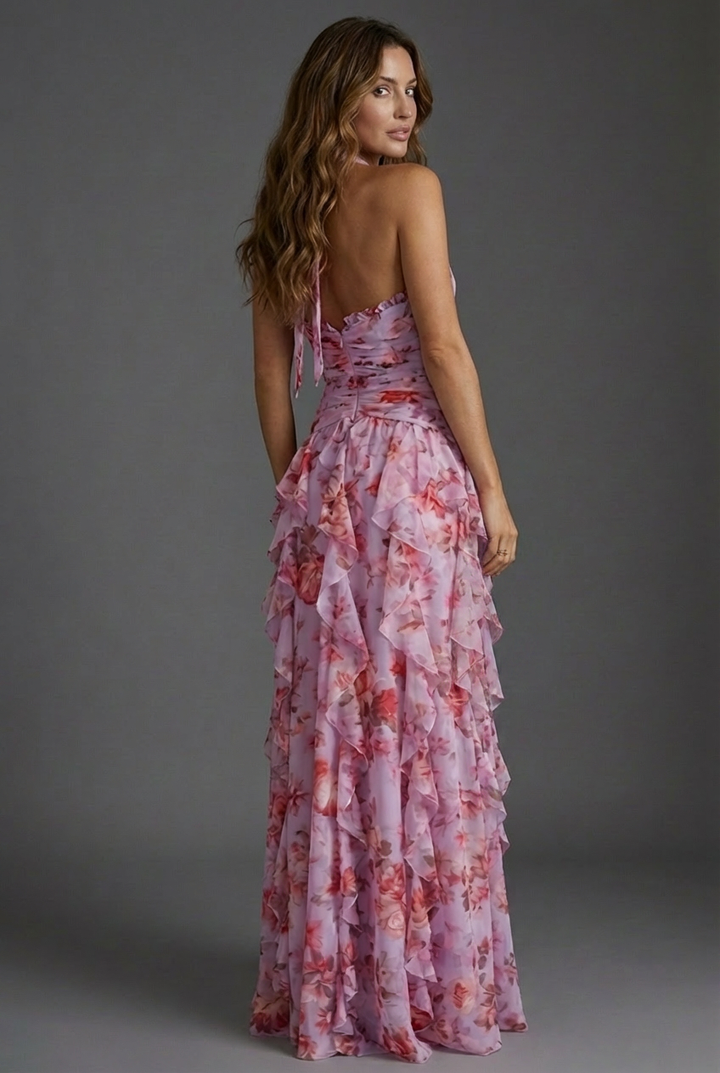 Flowy women's wedding guest dress featuring a vibrant floral pattern & chic halter design. Elegant occasion wear.