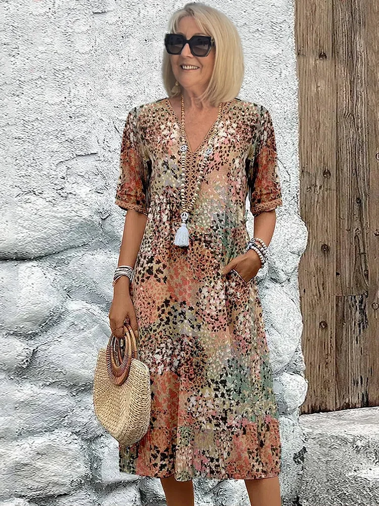 Full length view of a woman wearing a vibrant floral printed V-neck midi dress. Elegant A-line silhouette.