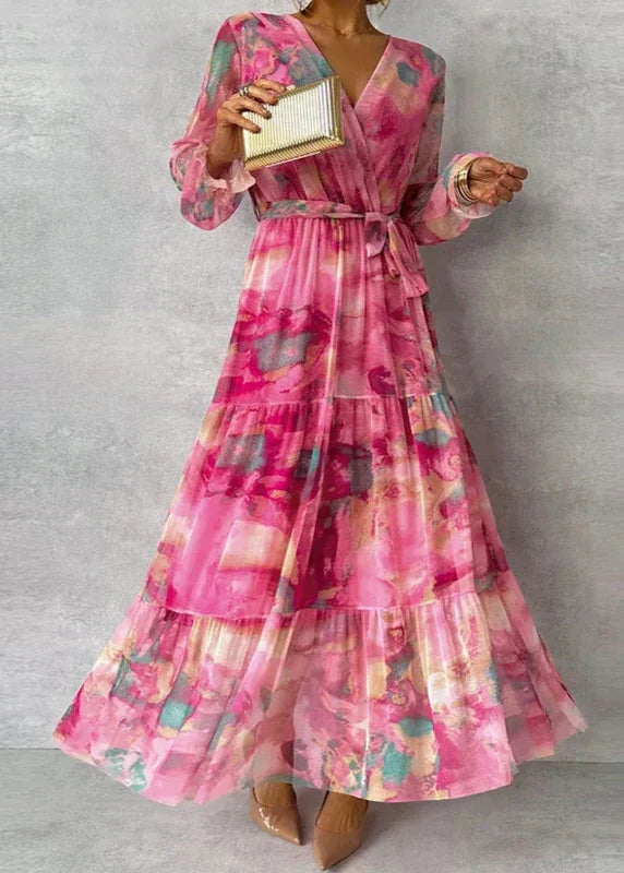 Chic women's wedding guest maxi dress. Features a vibrant floral print, V-neck wrap, and flowy tiered skirt.