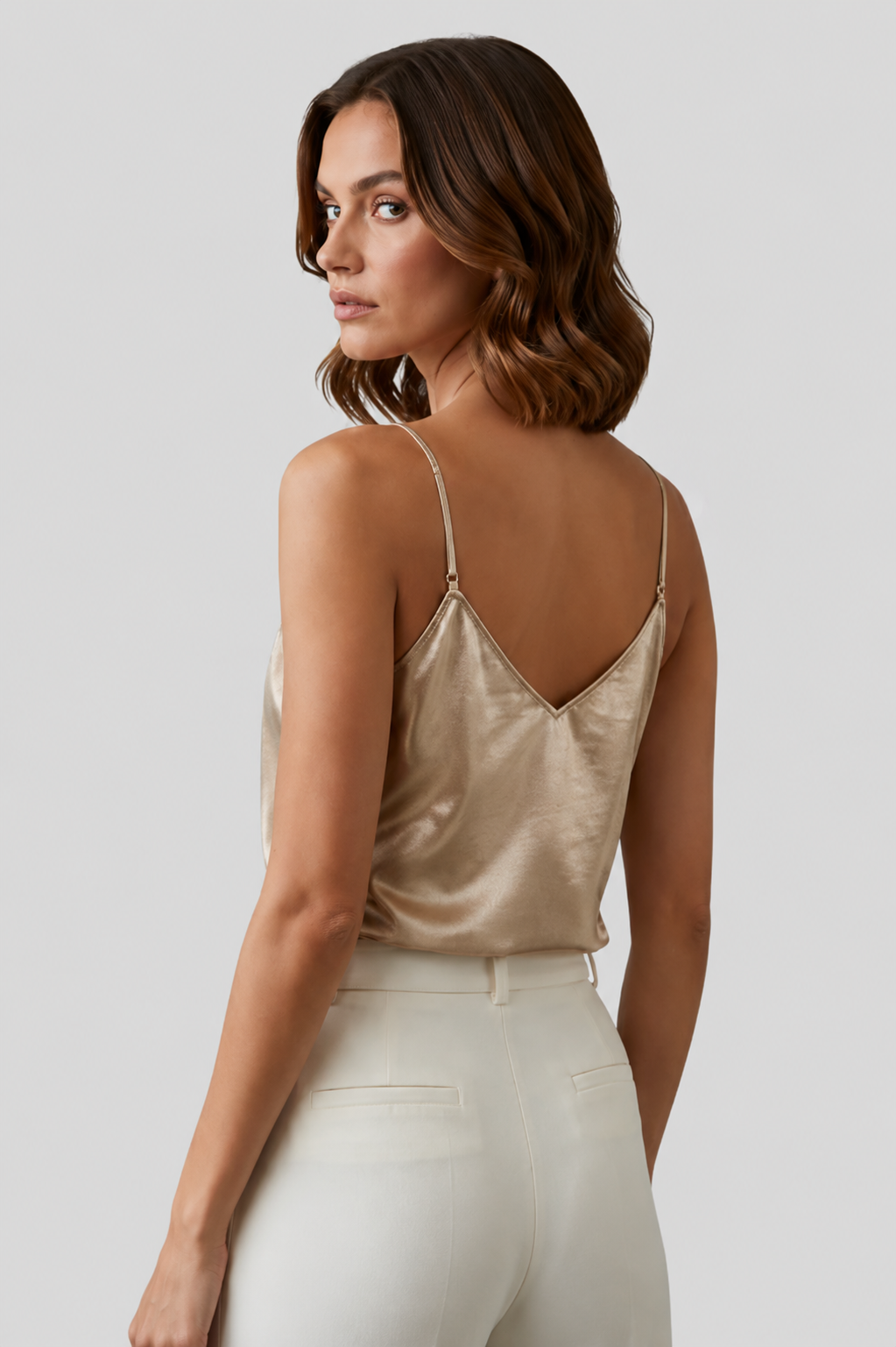 Close-up of a women's gold V-neck camisole, featuring delicate thin straps and an elegant design.