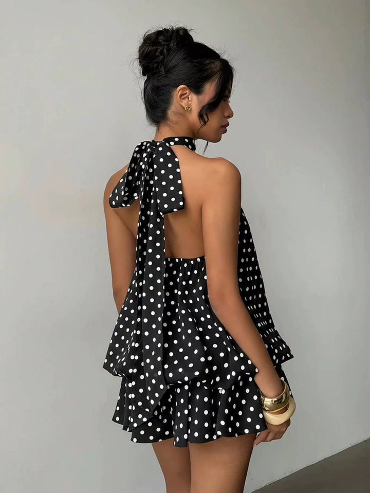 Women's elegant sleeveless trapeze mini dress, halter neck, with a pretty ruffle hem and an open back.