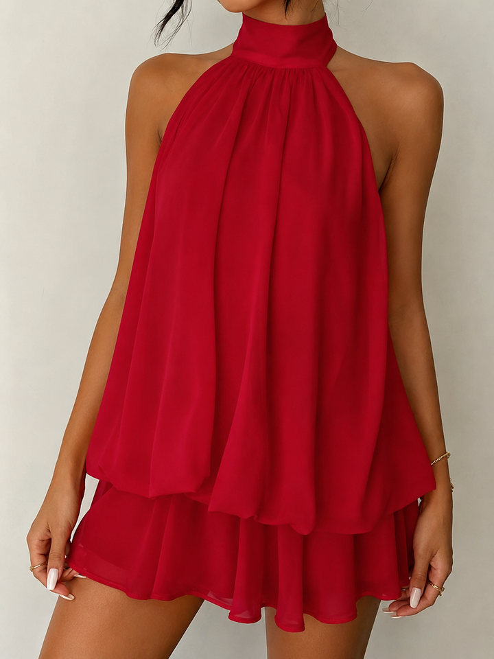 Women's cocktail attire: a chic halter mini dress with a graceful ruffle hem and an alluring open back.