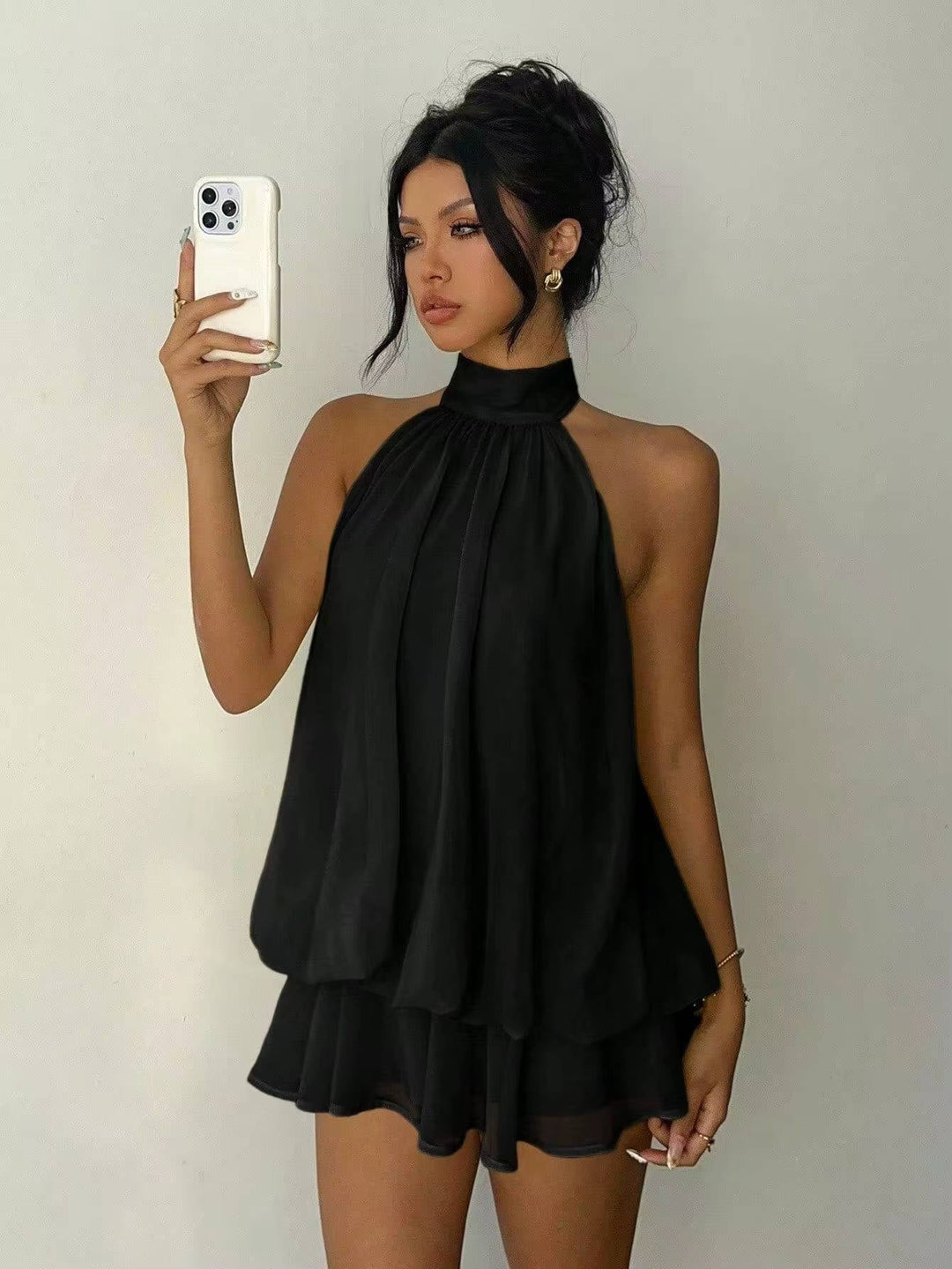 Trapeze-style women's halter mini dress with an attractive ruffle hem and a trendy open back.