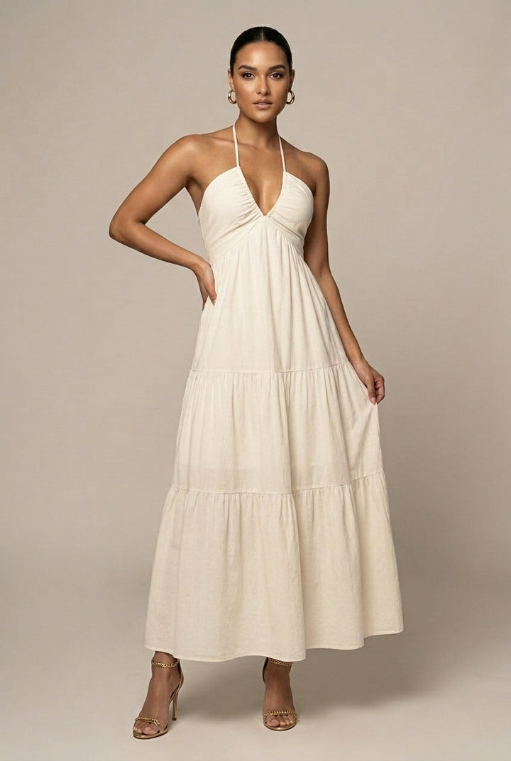Women's elegant halter neck maxi dress with tiered ruffle skirt, open back, and tie waist for special occasions.