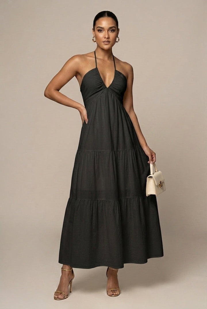 Wedding guest halter neck maxi dress, tiered ruffle skirt, open back, tie waist. Elegant women's occasion wear.