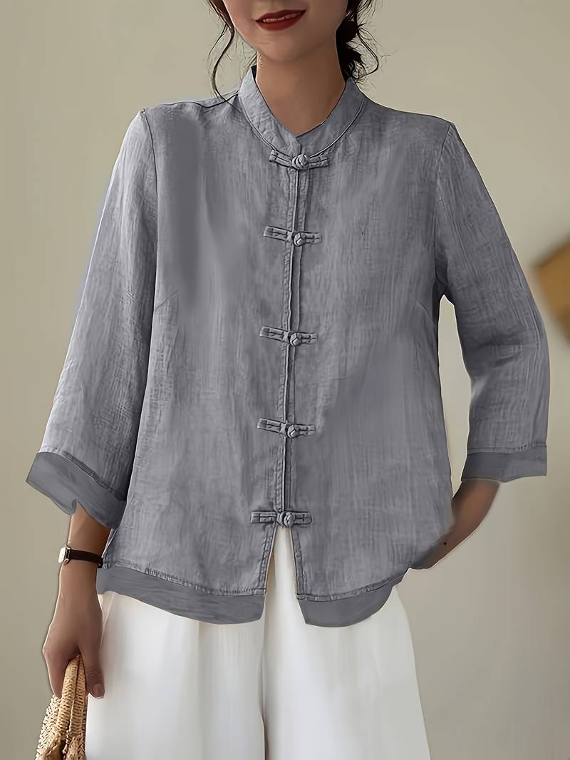 Casual women's top with a stylish mandarin collar and decorative frog button closure. Elegant work wear.