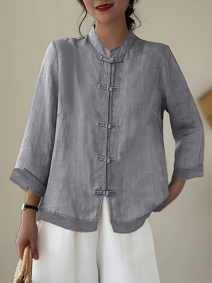 Casual women's top with a stylish mandarin collar and decorative frog button closure. Elegant work wear.