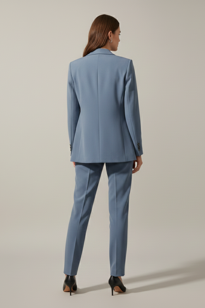 Side view of women's versatile business suit: notched lapel blazer & straight leg trousers, office fashion.