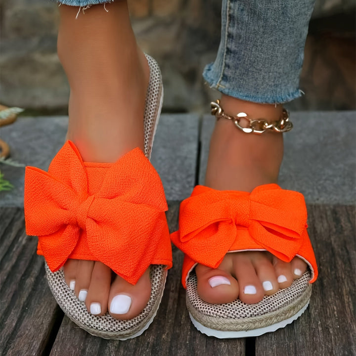 Stylish women's pearl bow slide sandals. Flat, comfortable, and elegant slip-on summer footwear for everyday and vacation.