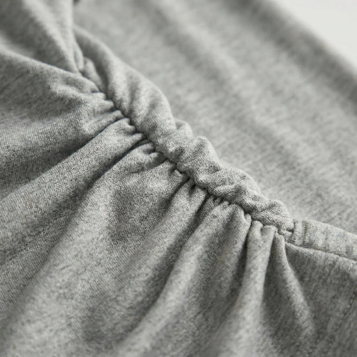 Modern women's ruched long sleeve top. A versatile layering piece for elegant or casual everyday fashion.