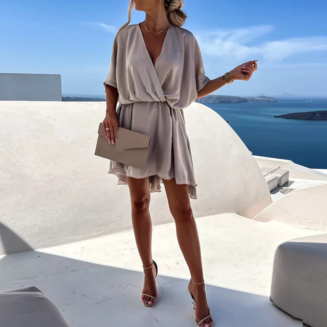 Women's elegant flowy wrap mini dress with a V-neck. Chic summer fashion & vacation outfit.