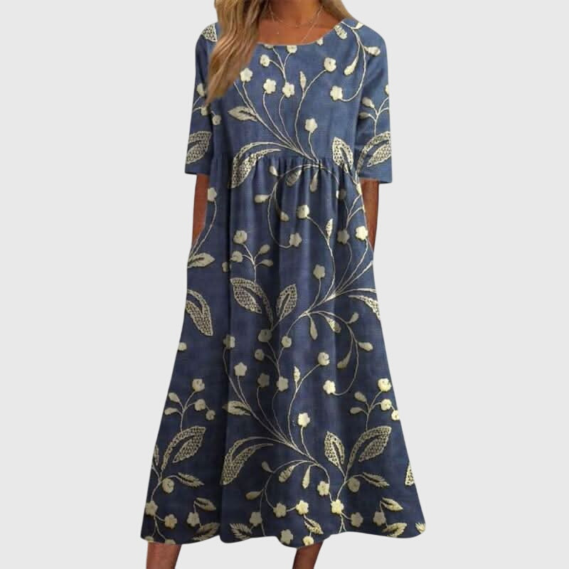 Women's embroidered flowy midi dress in a relaxed fit. Elegant and comfortable summer occasion dress for versatile wear.