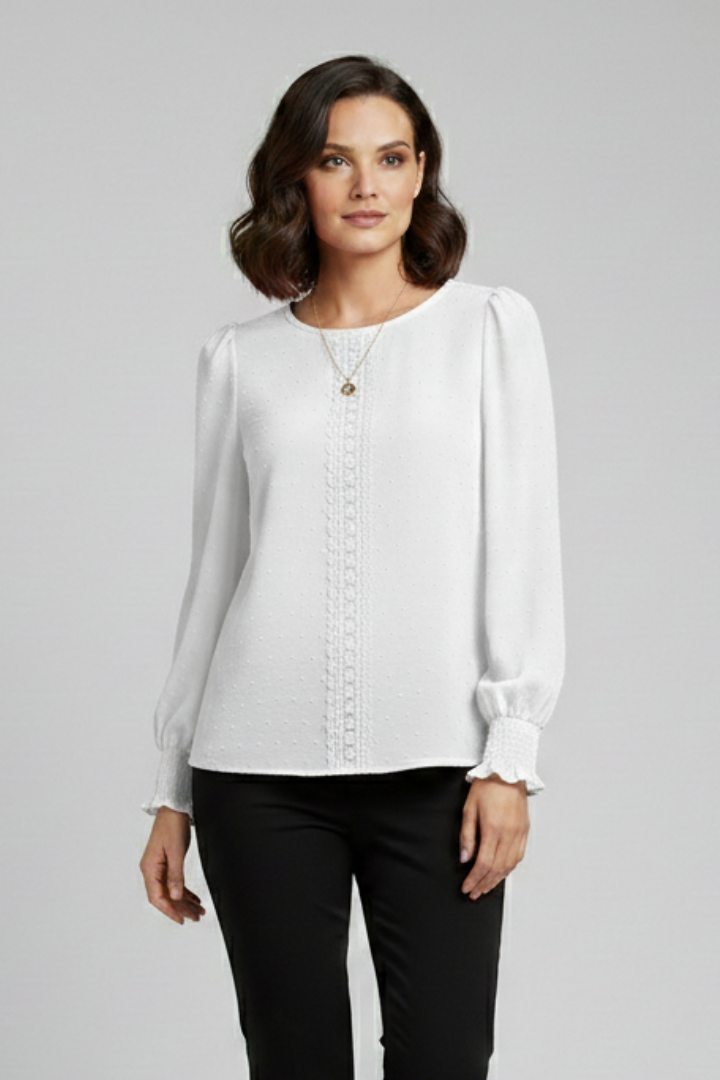Detailed view of women's embroidered long sleeve round neck blouse, delicate stitching.