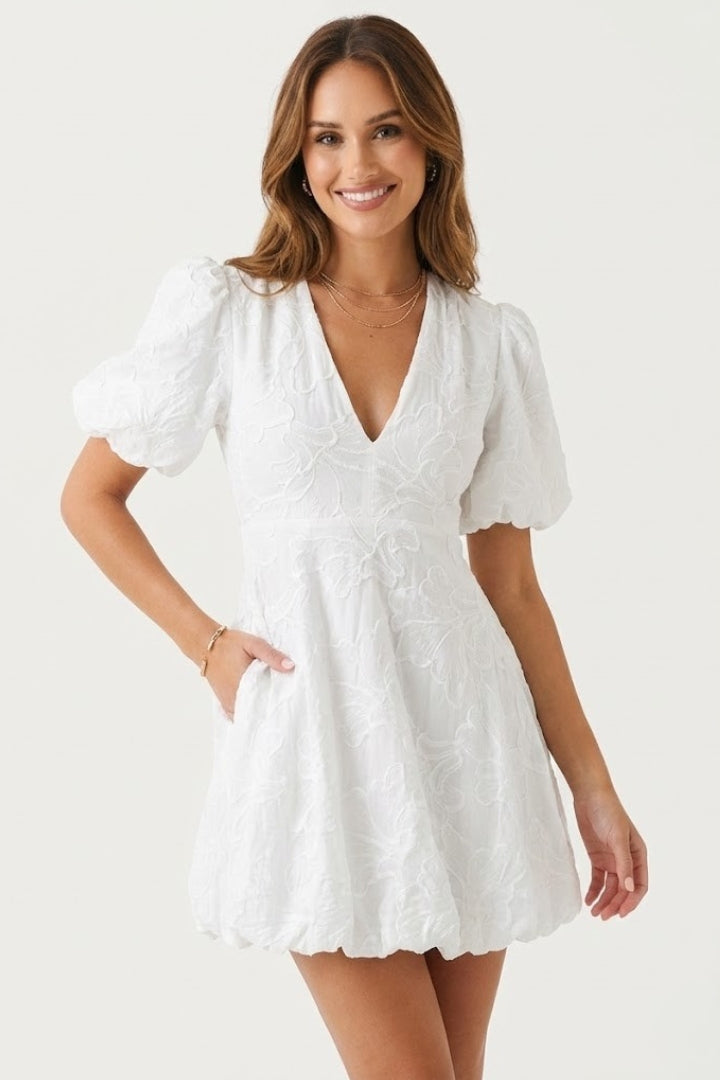 Textured women's dress with intricate floral embroidery, short puff sleeves, and a chic mini length.