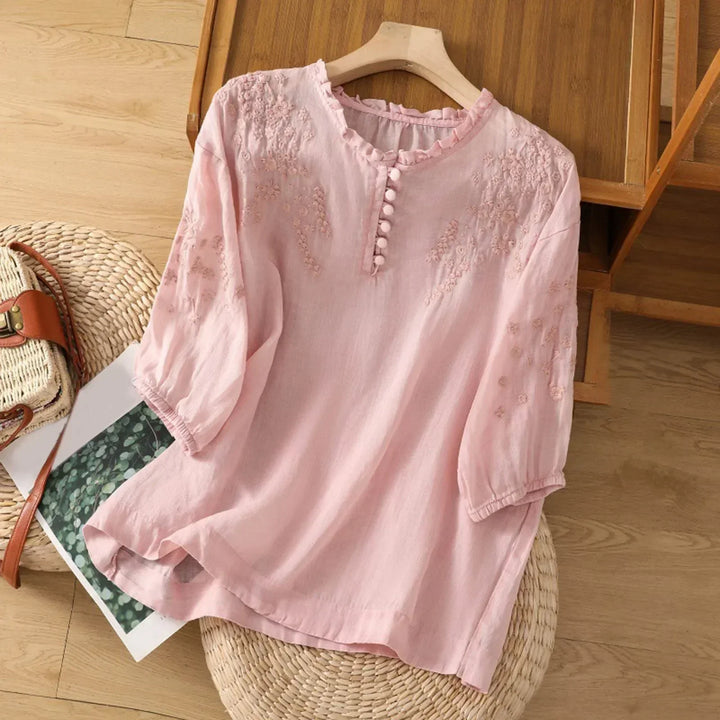 Elegant women's flowy embroidered short sleeve blouse with button neck. Ideal for spring and summer chic style.