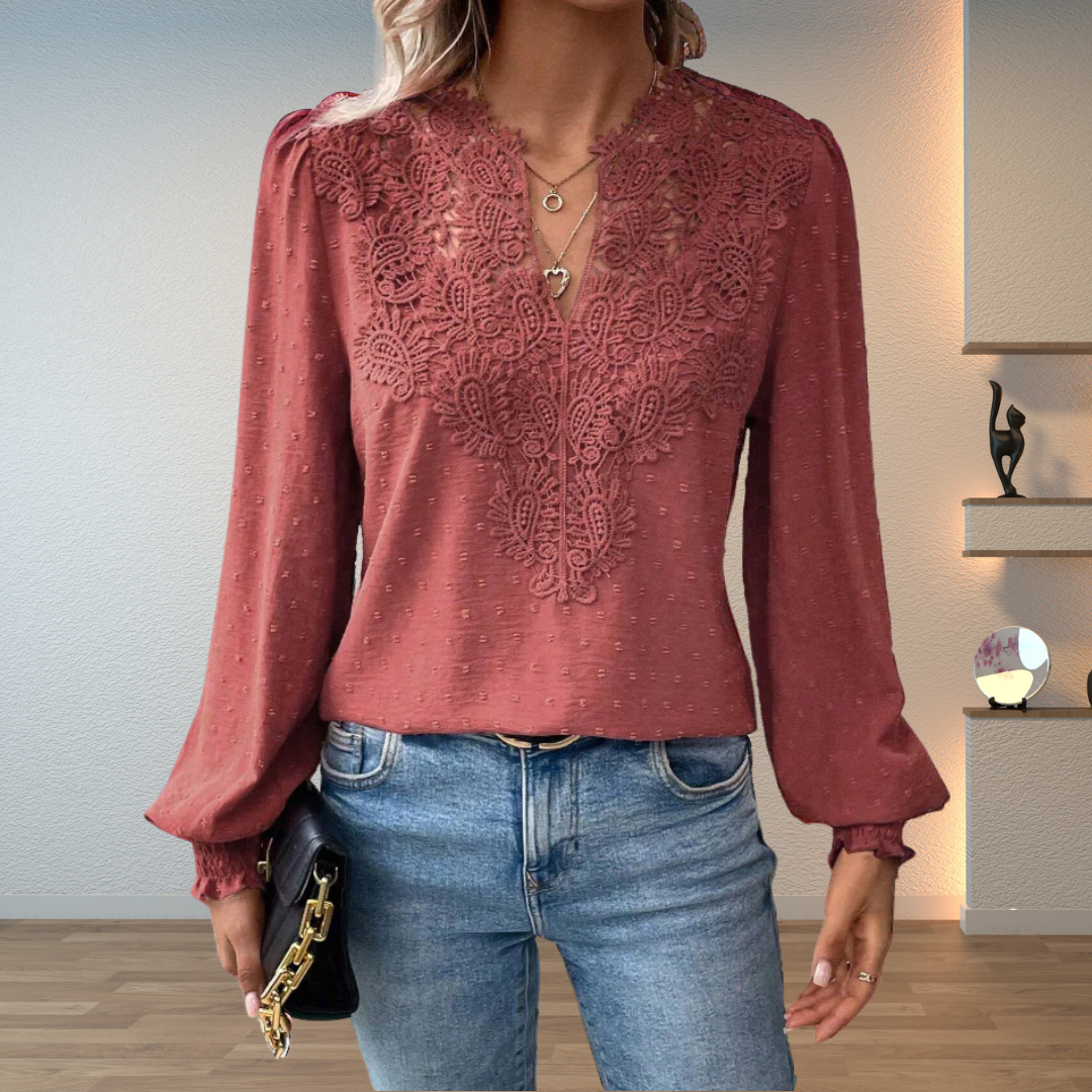 Close-up of delicate embroidery on a women's V-neck long sleeve blouse, high quality detail.