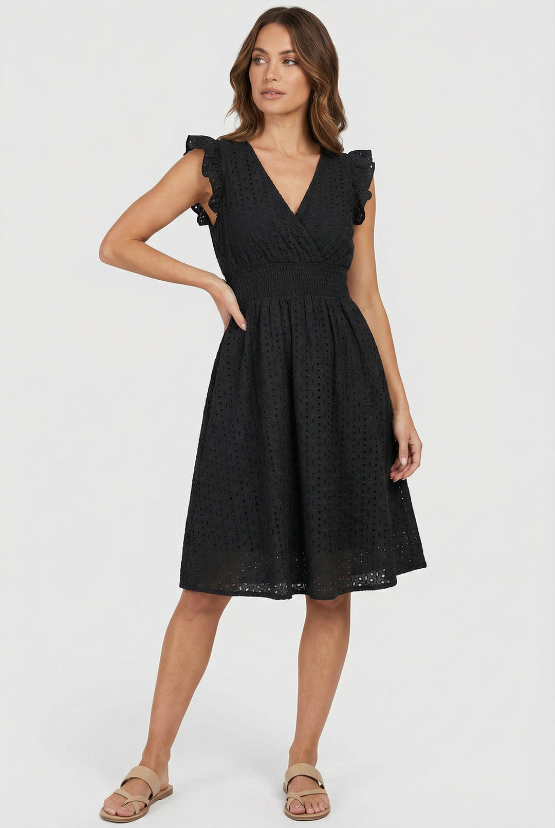 Boho-inspired women's eyelet dress with a flattering flared shape and delicate ruffled cap sleeves.