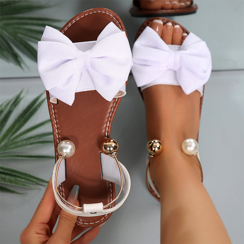 Versatile women's flat sandals with charming bow & bead embellishments for all-day summer comfort.