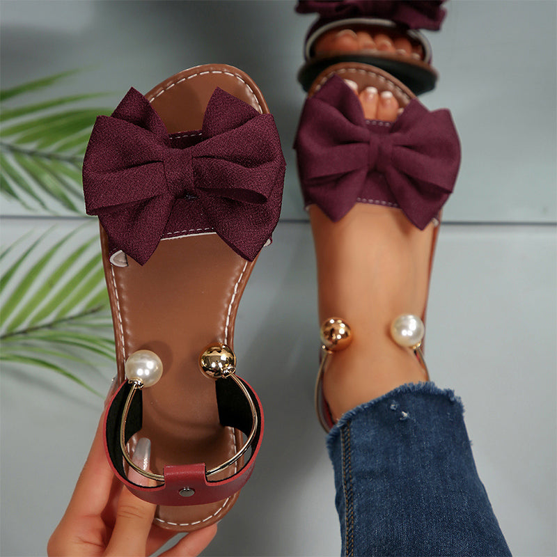 Chic women's flat open-toe sandals. Perfect summer footwear with delightful bow & bead details.