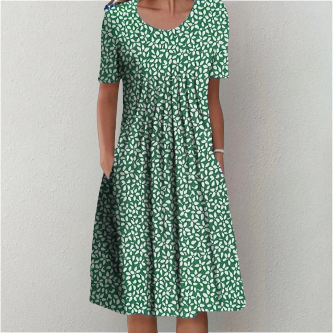 Model wearing a comfortable women's floral casual midi dress. Short sleeves, A-line cut, round neck & pockets.