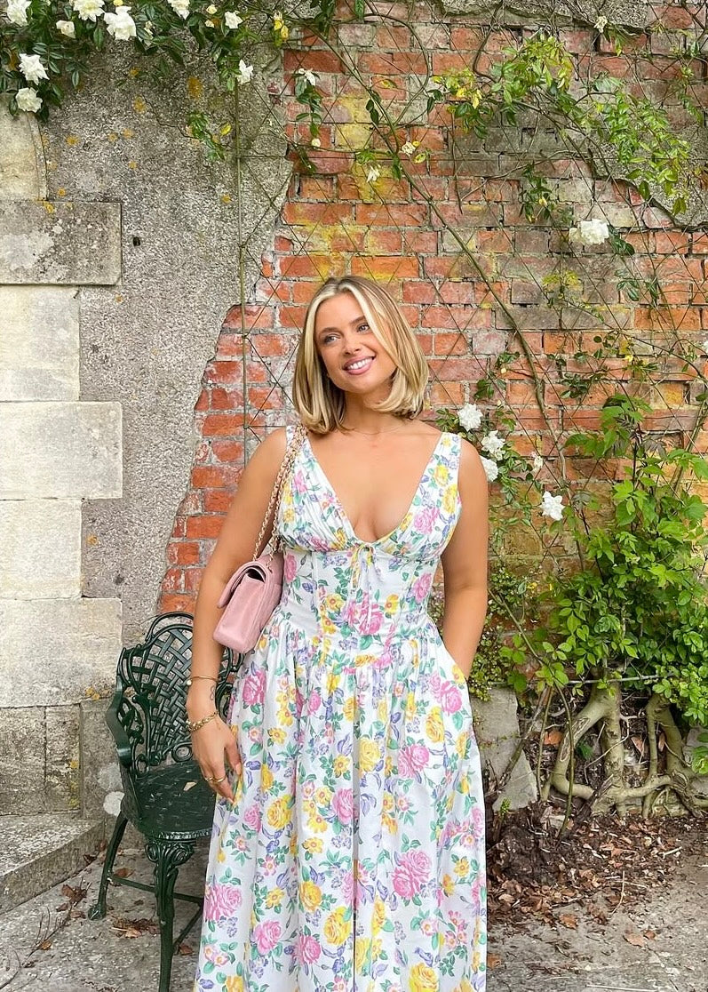 Chic women's floral midi wedding guest dress, boasting a V-neckline and elegant corset detail. A-line fit.