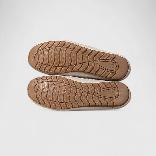 Close-up of women's ballet flats, highlighting the intricate perforated & floral cutout design. Stylish slip-on shoes.