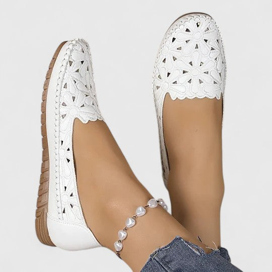 Elegant women's slip-on ballet flats with intricate floral cutout & perforated pattern. Perfect for casual spring style.