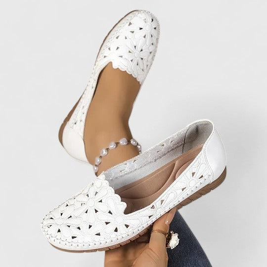 Side view of women's perforated floral cutout ballet flats. Slip-on design offers comfort & casual everyday elegance.