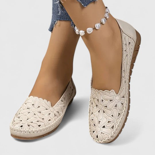 Front view: Women's round toe slip-on ballet flats with delicate floral cutout and perforated pattern for spring fashion.