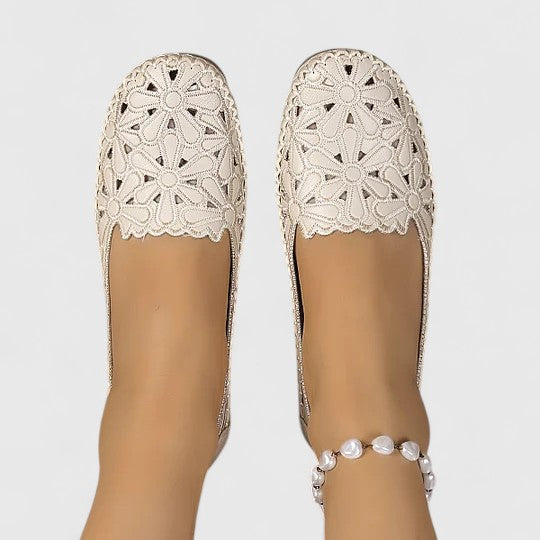 Back view of women's comfortable slip-on ballet flats, featuring perforated floral cutout details. Great for summer.