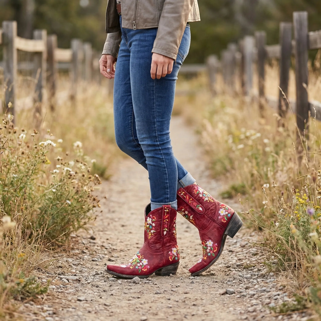 Women's floral embroidered western ankle boots with pointed toe & block heel. Stylish festival footwear.