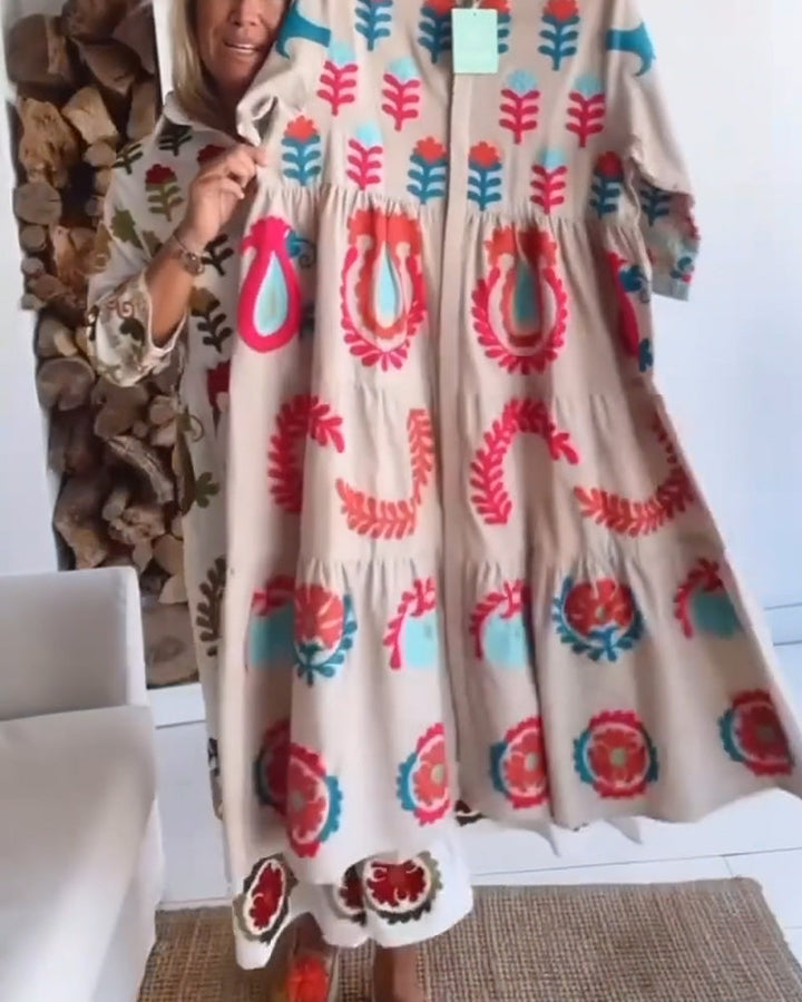 Flowy women's midi dress featuring a vibrant floral graphic print and a classic lapel collar detail.