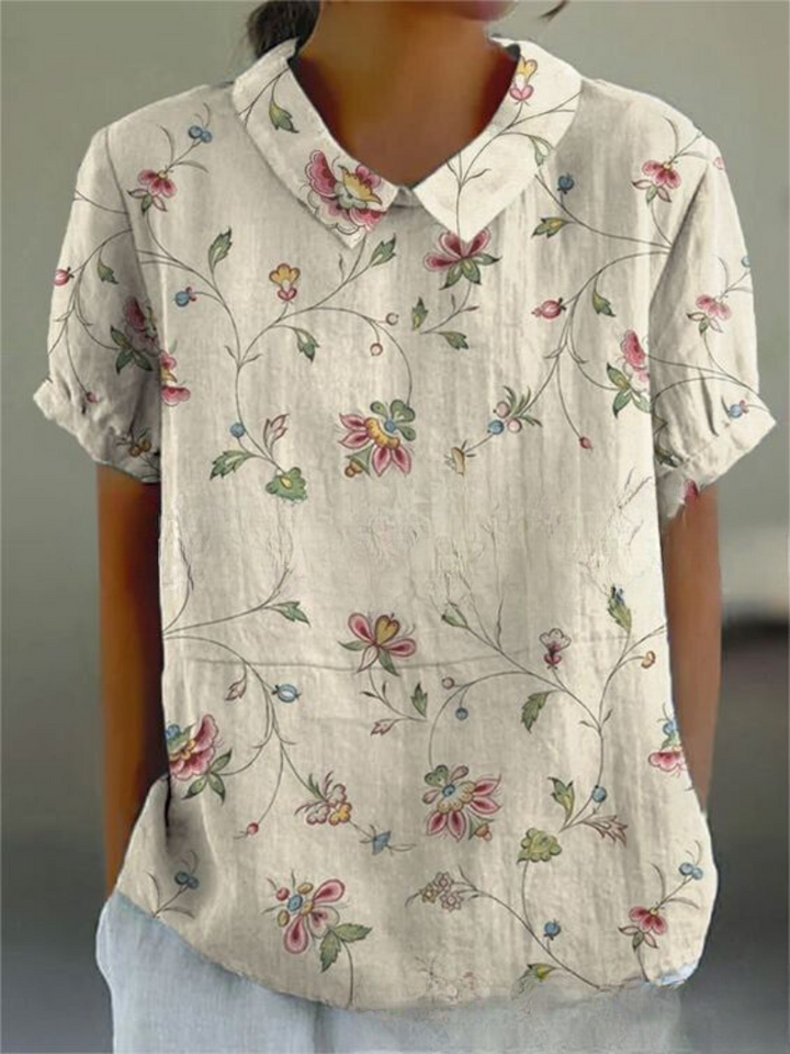 Vibrant floral print women's collared blouse with short sleeves. A relaxed fit stylish top for summer casual wear.