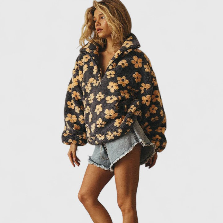 Close-up of women's floral pattern on a quarter-zip pullover sweater, chic & comfortable.