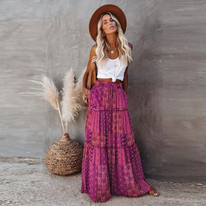 Flowy women's summer maxi skirt with vibrant floral print and elegant tiered structure, elastic high waist.