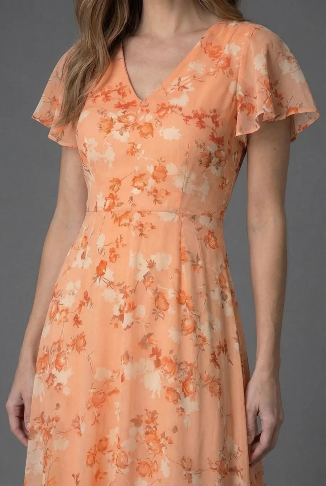 Elegant women's maxi dress featuring a vibrant floral print, V-neckline & delicate flutter sleeves. Ideal for events.