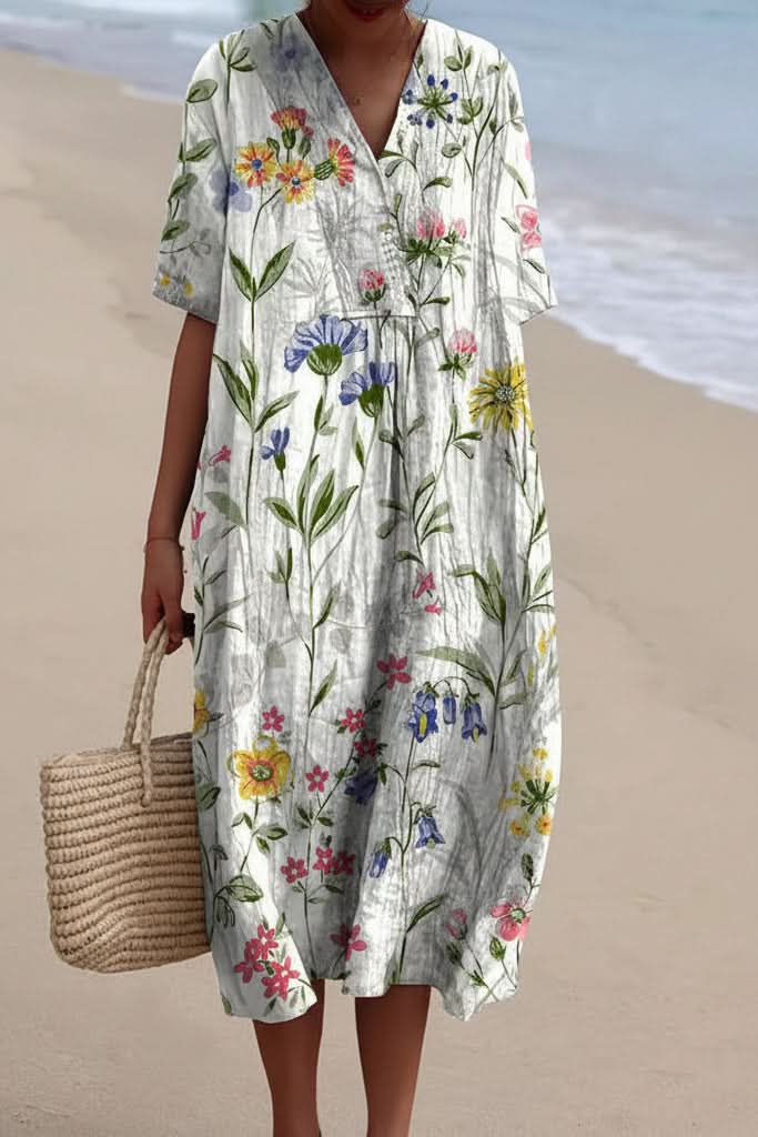 Woman enjoying a beach vacation in a flowy floral V-neck midi dress. Effortless summer style, comfortable fit.