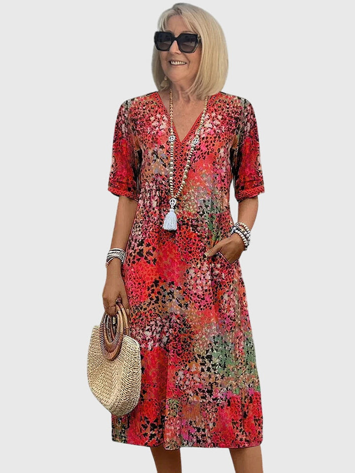 Boho-style women's summer midi dress featuring a vibrant abstract botanical print and comfortable v-neck.