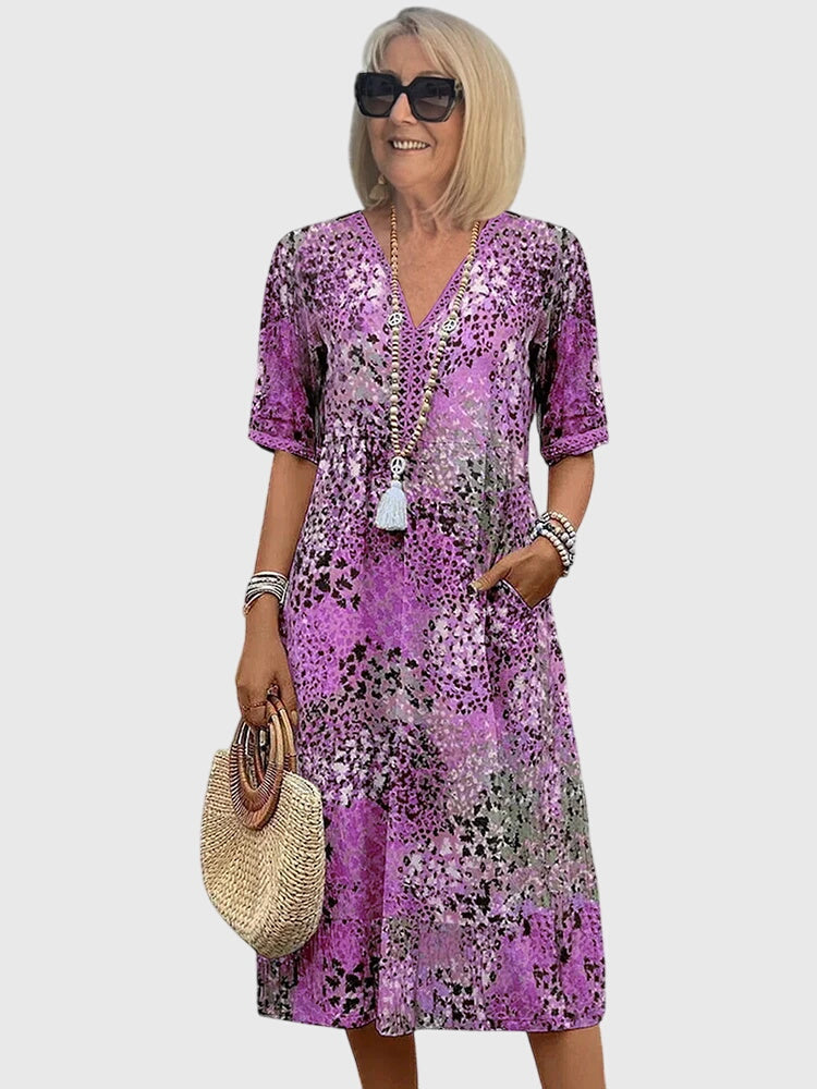 Full shot of women's v-neck midi dress, vibrant abstract print, flowy fabric, flutter sleeves, ideal for summer.