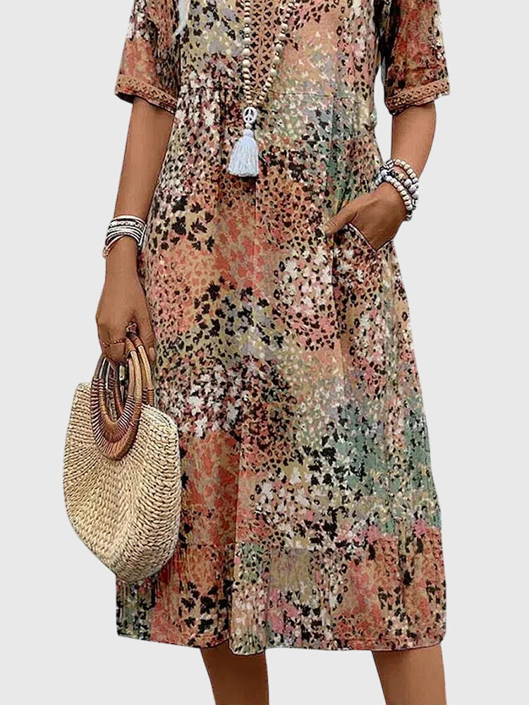 Chic women's flowy abstract print midi dress. Features v-neck, flutter sleeves & a comfortable relaxed fit for summer.