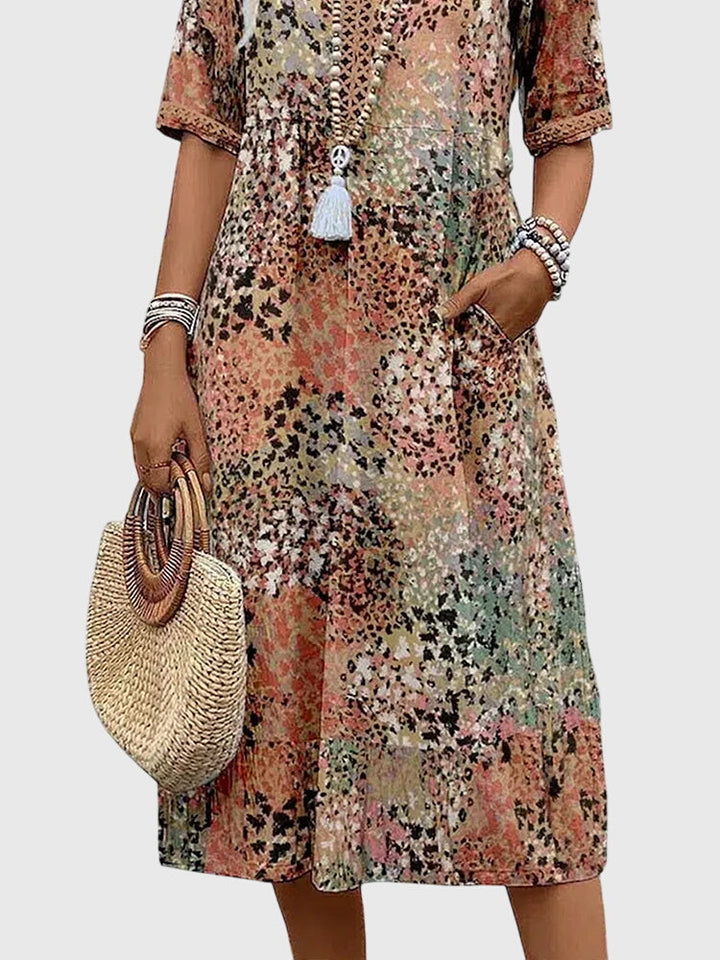Chic women's flowy abstract print midi dress. Features v-neck, flutter sleeves & a comfortable relaxed fit for summer.