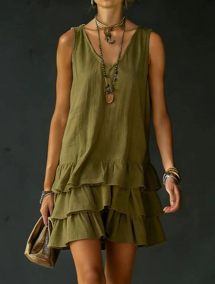 Relaxed fit women's V-neck mini dress. Flowy fabric, tiered design, and ruffles ensure comfortable summer casual wear.