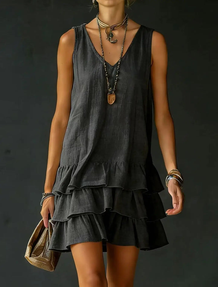Close-up of the delicate ruffles and tiered design on a women's V-neck mini dress. Flowy, chic summer style.