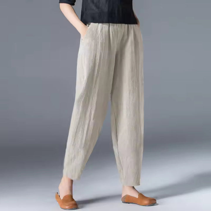 Woman walking in relaxed fit flowy summer trousers. Comfortable travel pants for casual everyday wear & warm weather.