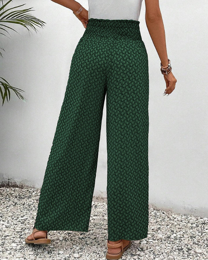 Women's wide-leg trousers with geometric print, relaxed fit. Shows flow & movement for elegant casual wear.