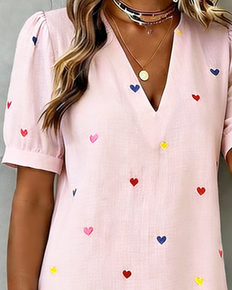 Lightweight women's summer casual dress with a playful heart print, V-neck, and stylish puff sleeves.