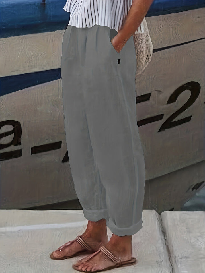 Breathable women's summer pants, high waist & relaxed fit, with trendy roll hem detail.