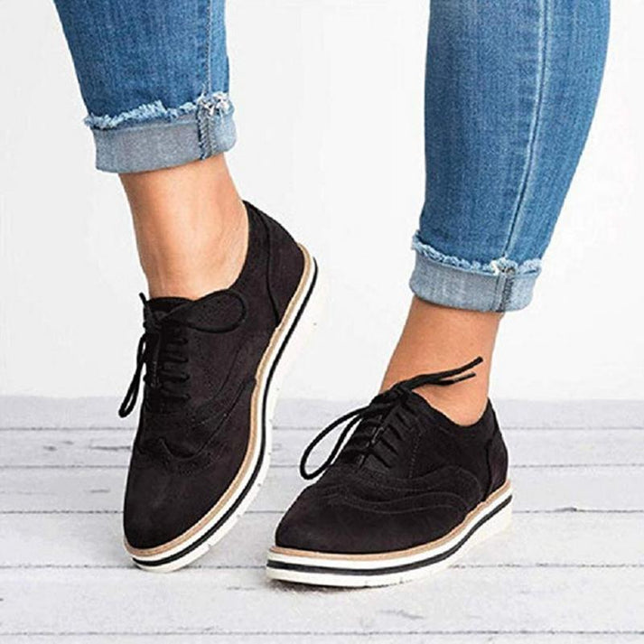 Elegant women's lace-up sneakers, blending oxford and brogue details for a stylish and comfortable everyday shoe.