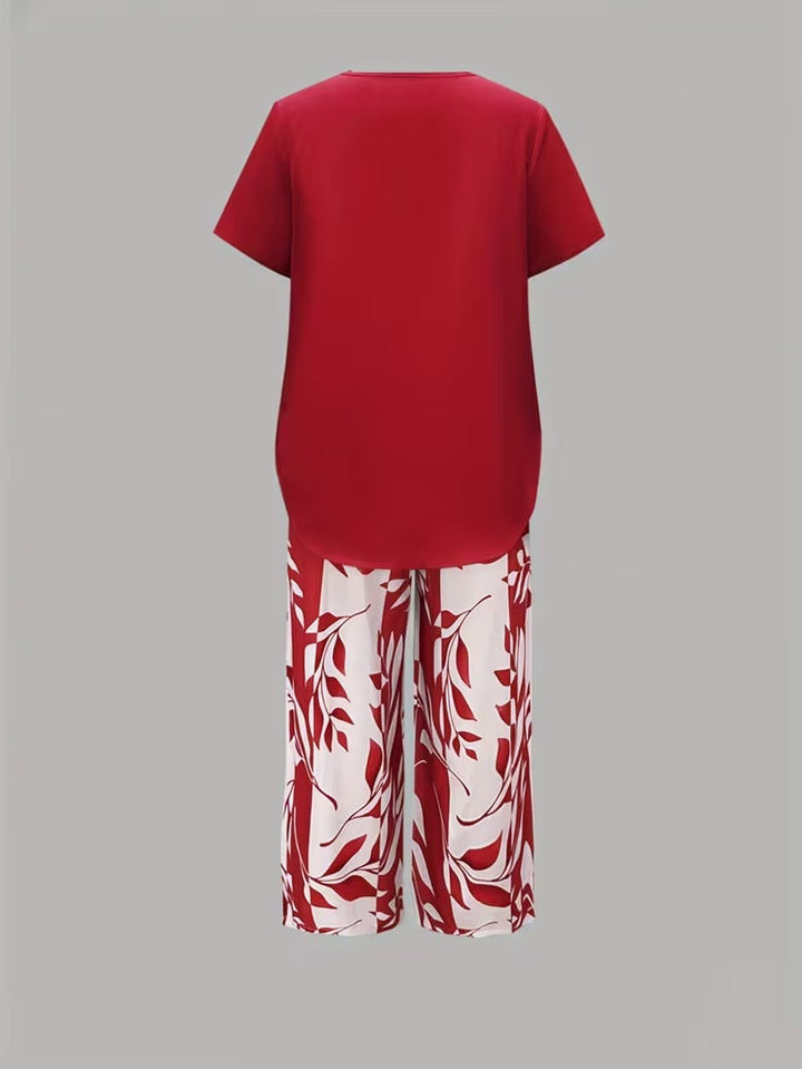 Close-up detail of botanical leaf print on women's two-piece outfit. Short sleeve top fabric & elegant pants.
